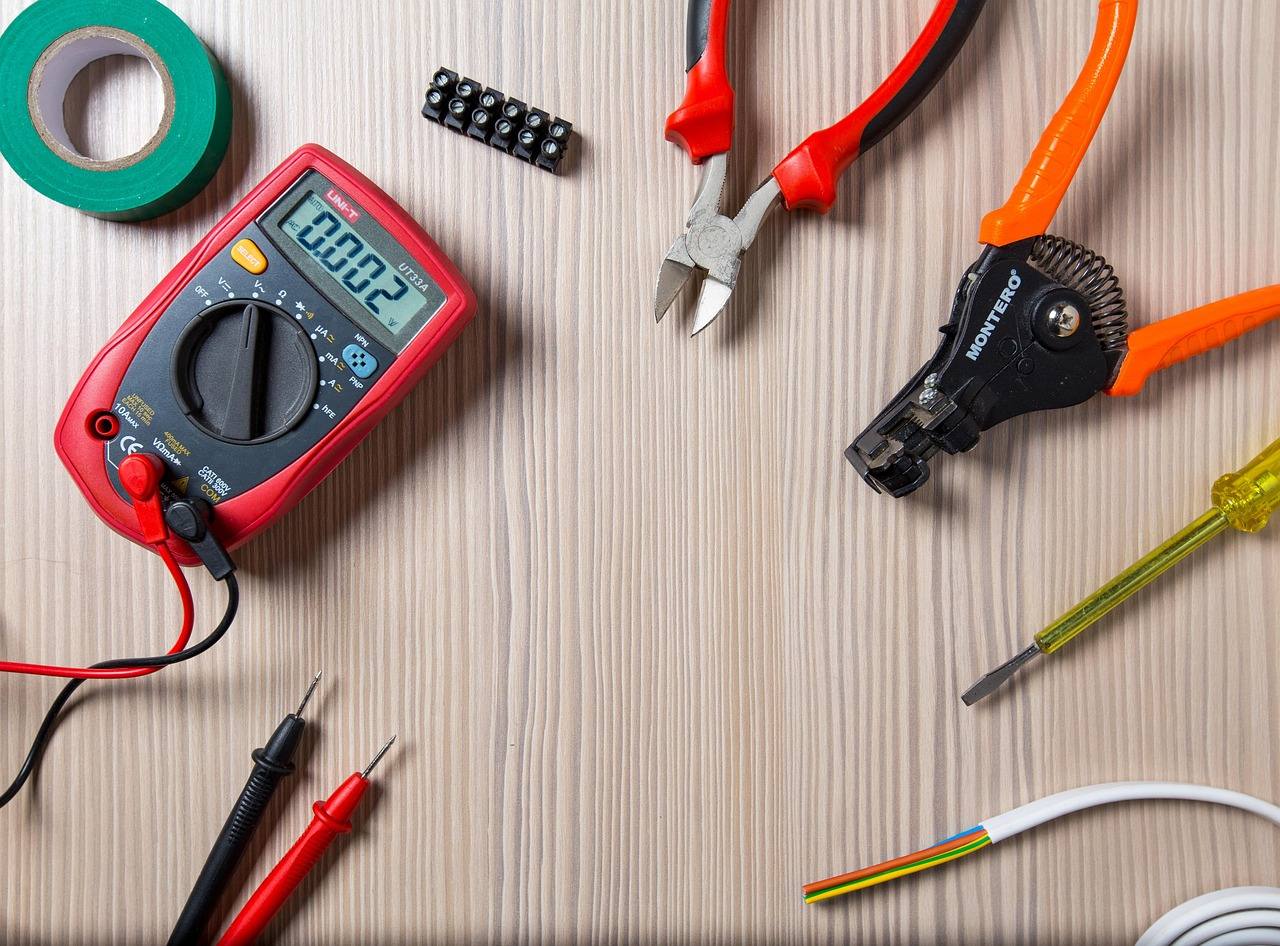 Electrician tools on a workbench: side cutters, tester, wire